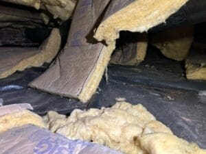 yellow floor insulation falling from the crawl space joists