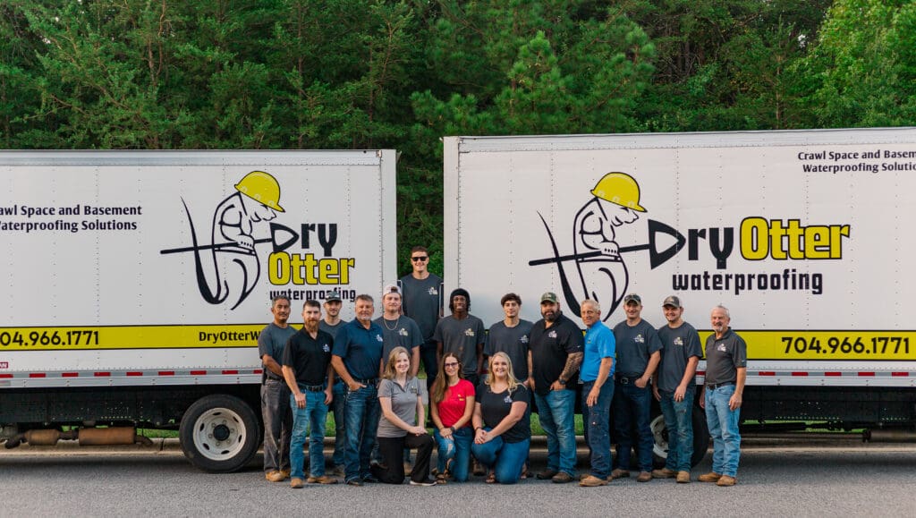 group photo of Dry Otter Waterproofing Staff and box trucks