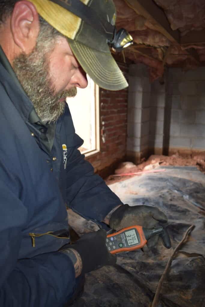 Inspector measures relative humidity in crawl space at a reading of 77%RH