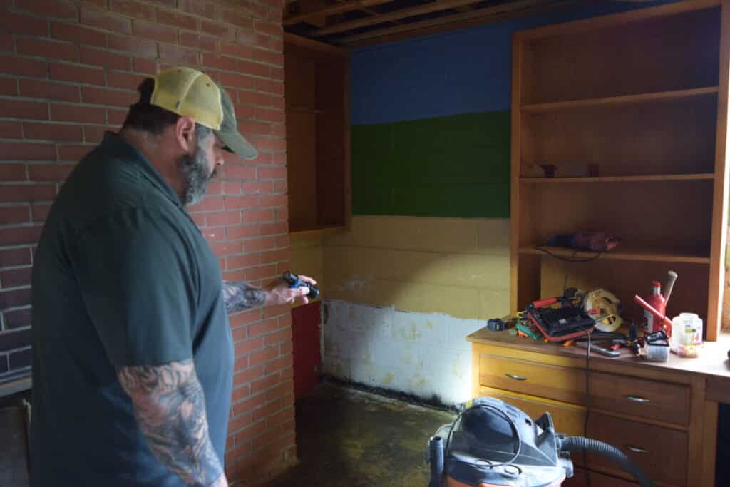 Inspector Marcus looks at the waterproofing paint  on a wall that has lots of other fun paint colors