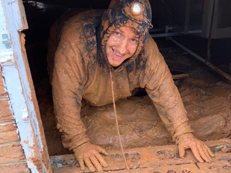 muddy worker in a crawl space